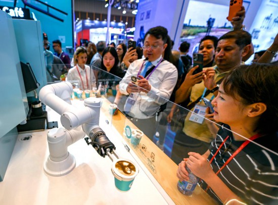 10月15日，在第138届广交会服务机器人专区，展商向观众展示一款商用咖啡机器人设备。新华社记者 肖恩楠 摄